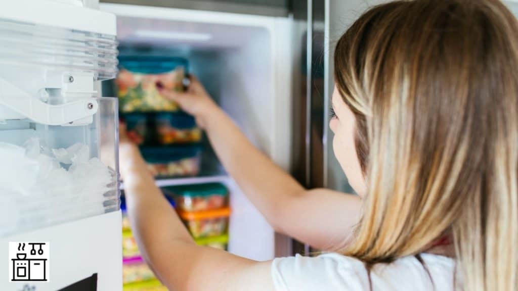 Image of a woman placing food in a freezer