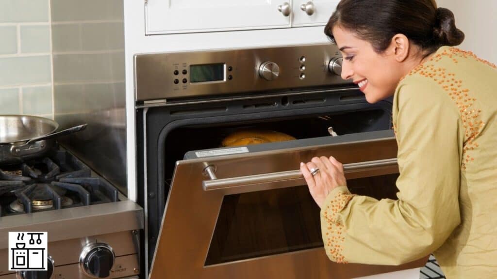 Image of a woman about to keep stainless steel bowl in the oven