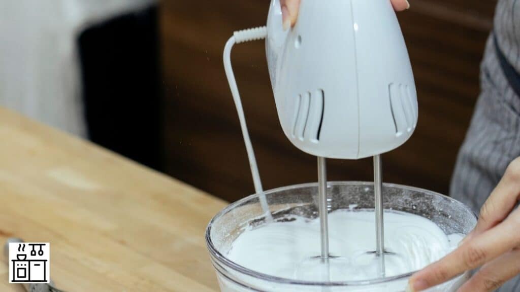 Image of a woman frothing milk with a hand mixer