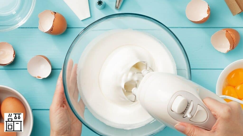 Image of a woman making meringue with a hand mixer